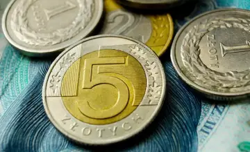 Monety 5 zł, 2 zł i 1 zł na tle banknotu. Obrazek symbolizuje zarobki, w tym średnią płacę w Polsce.